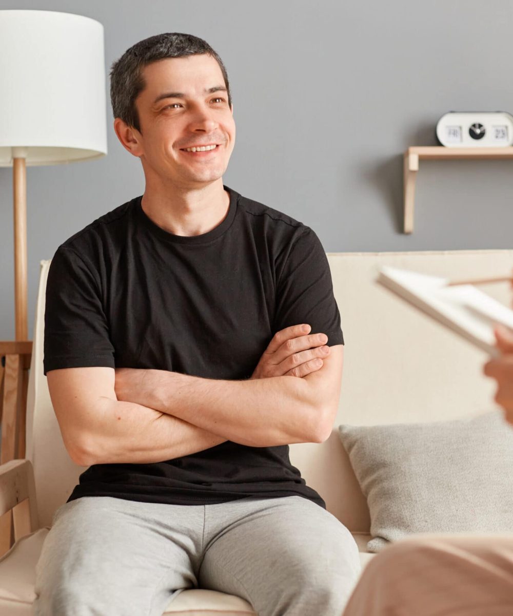 Psychologist with clipboard advising patient in clinic smiling man enjoying consultation solving mental problems smiling , psychotherapy session.